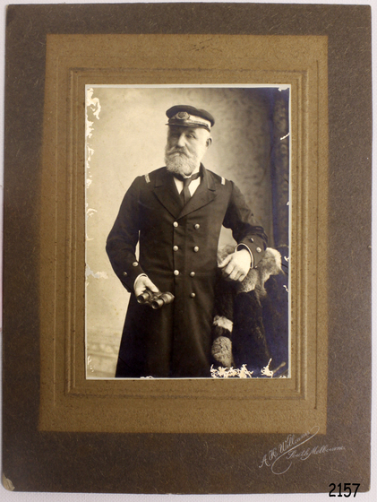 Older man posing in captains uniform with hat