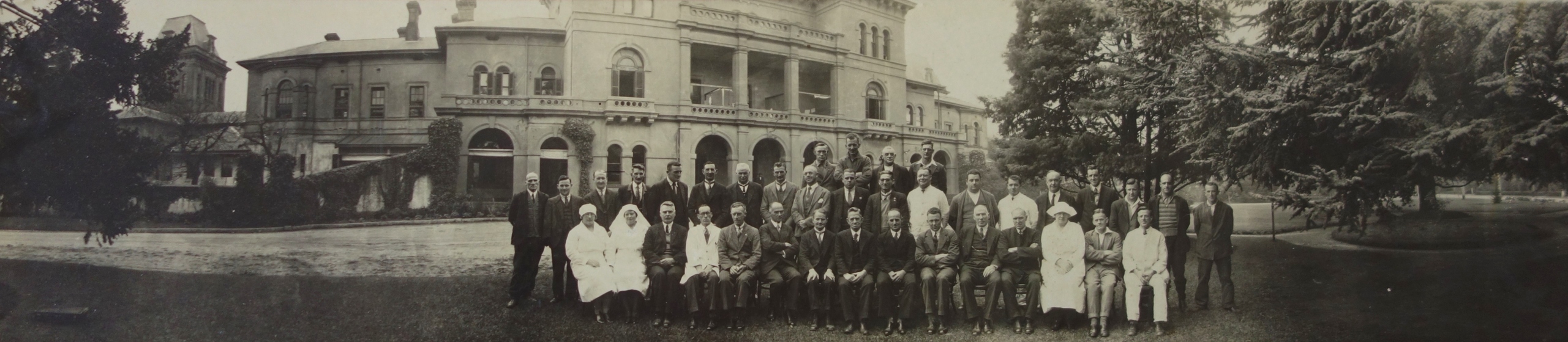 Group of staff men and women in front of building