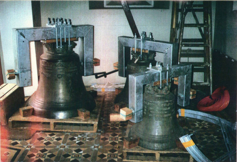 Three bells on pallets on display