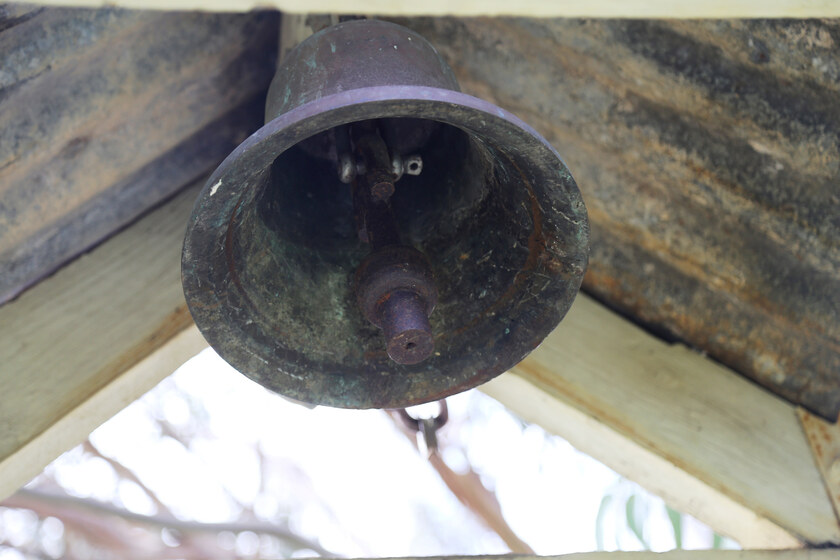 Large metal bell hanging from ceiling