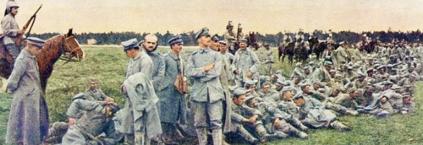 military men form a line and wait seated on the grass