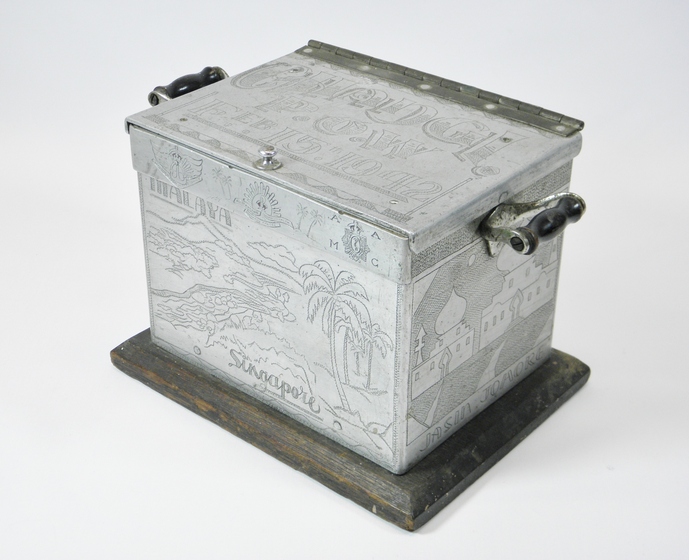 Metal box with engraved palm trees and buildings