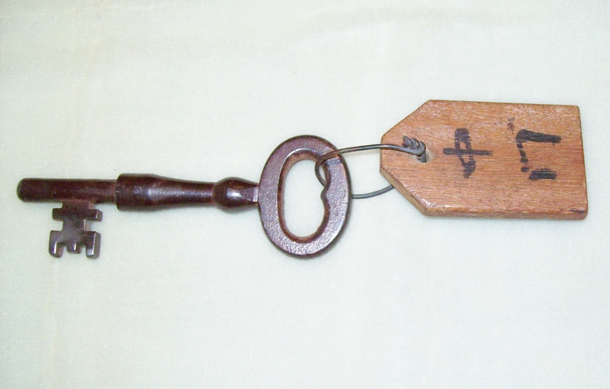 Metal key on wooden tag connected with wire