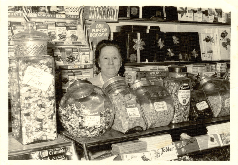 a woman behind a lolly shop counter