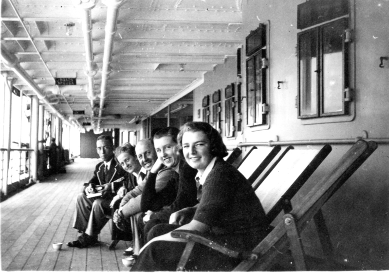 uniformed men and women sitting on deck chairs