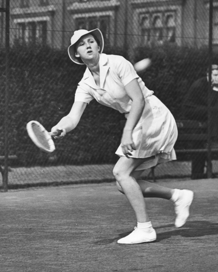 Nancy Wynne playing tennis in England, black and white