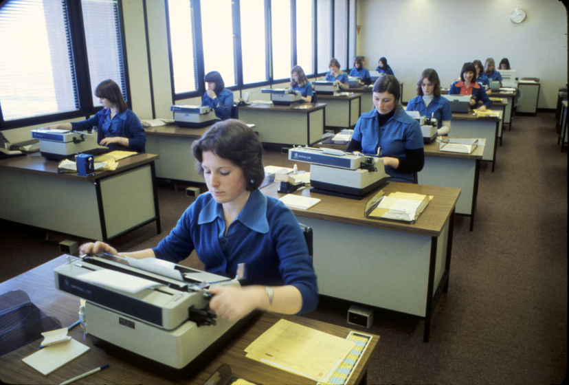 Women typists sitting at desks in rows
