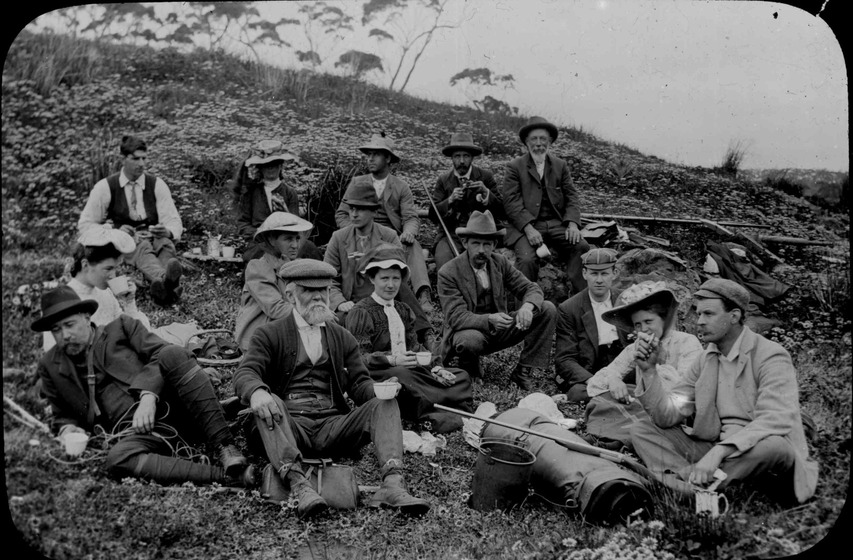 A social gathering of men and women, resting in the countryside.