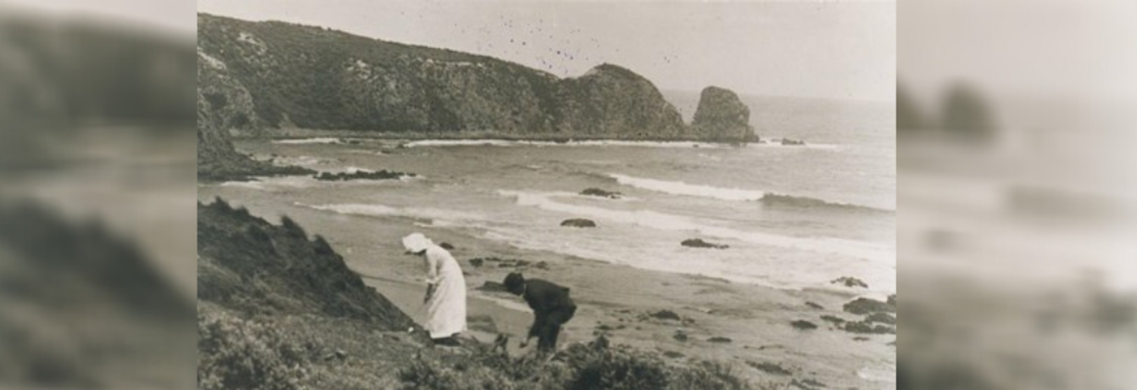 man and woman on hill overlooking beach
