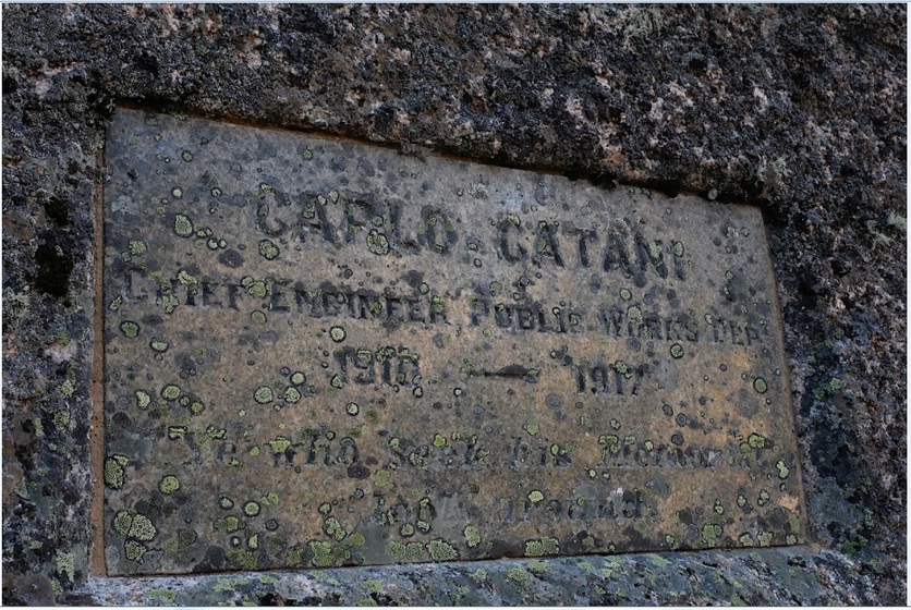 a plaque in a rock covered in lichen