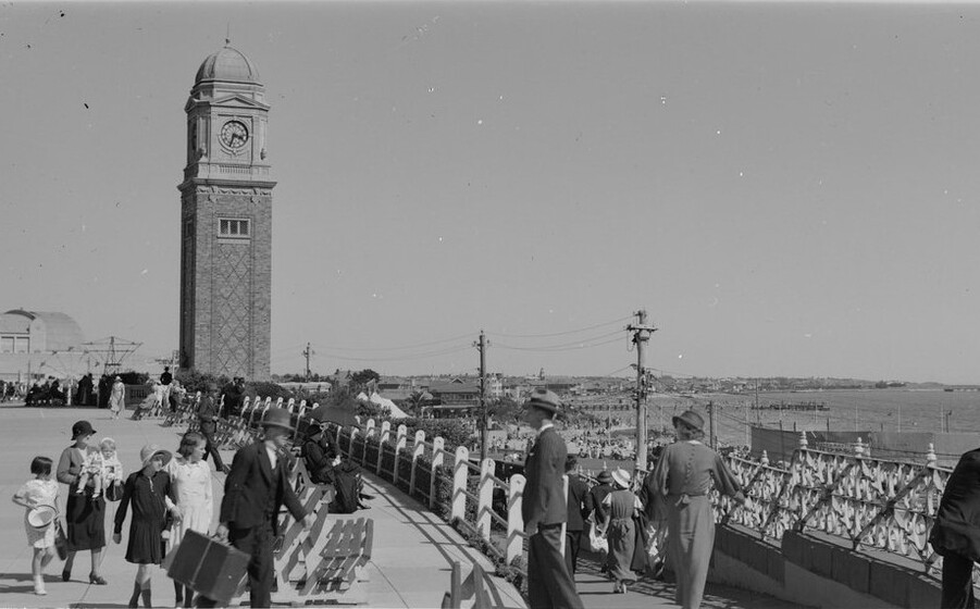 a clocktower stands high on a crowded warefront