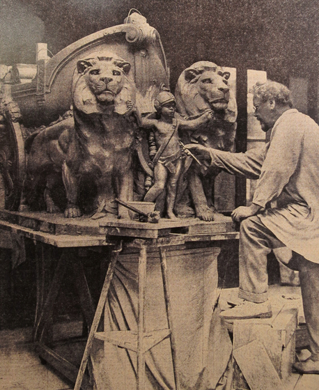 A sculptor at work in his studio surrounded by stone sculptures