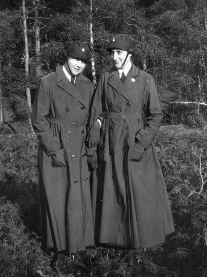Two women outside in a park in uniforms