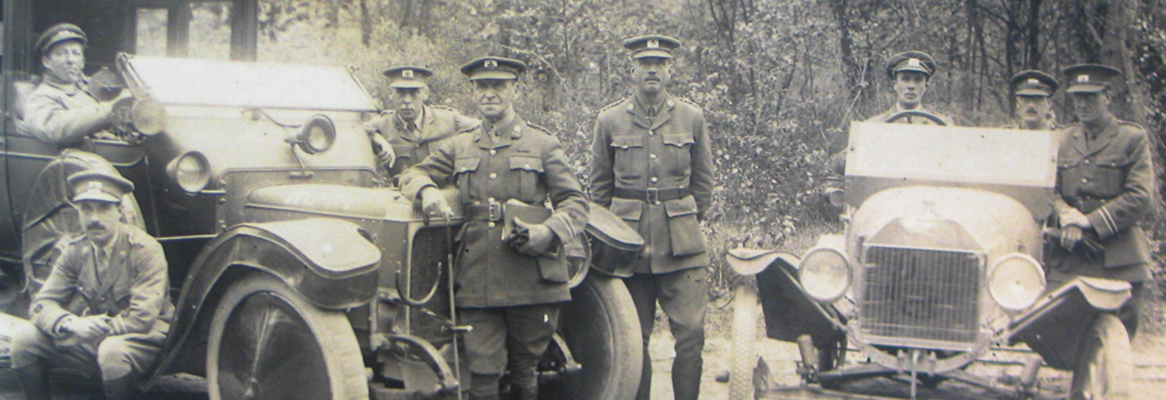 Photograph of a car and a number of men in uniform 