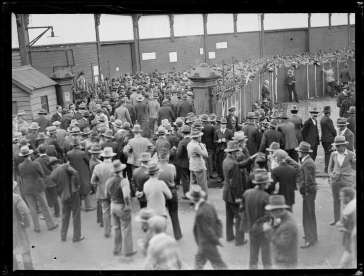 A black and white photograph of a large group of men gathered outdoors