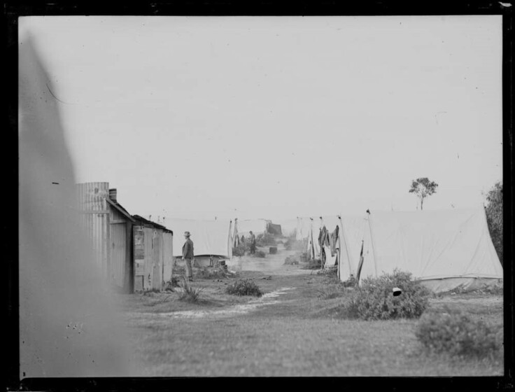 A black and white photograph of a group of tents.