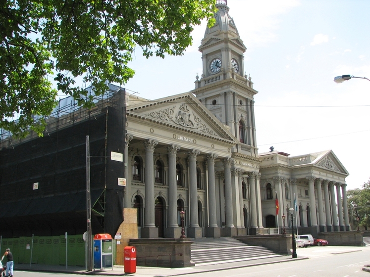 Front facade of historic town hall with columns and clock tower
