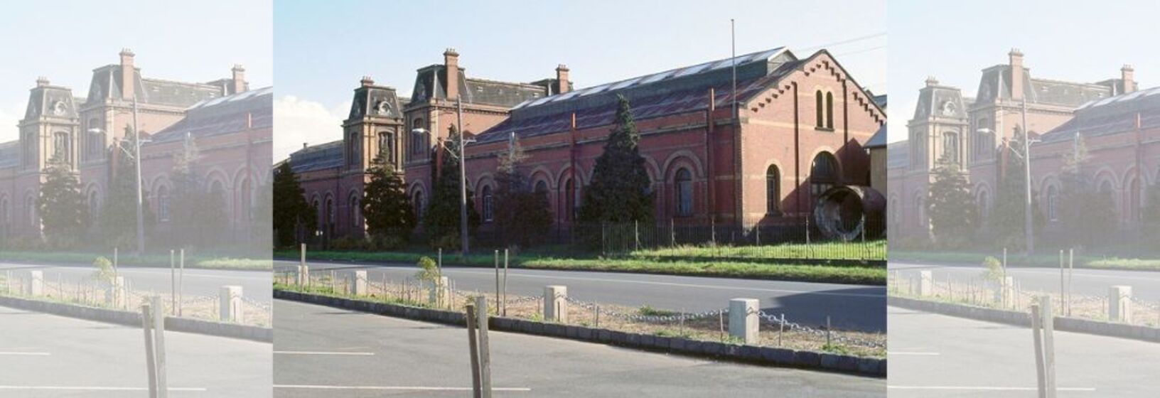 A brick veneer building, French chateau style 19th century pumping station in the background with a street and carpark in the foreground