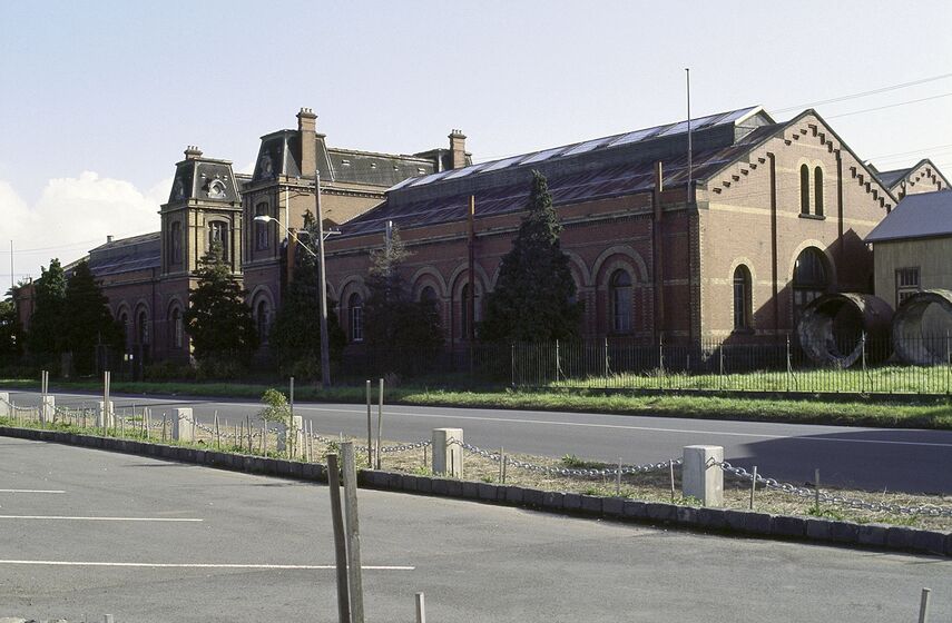 Historic brick building by bitumen carpark