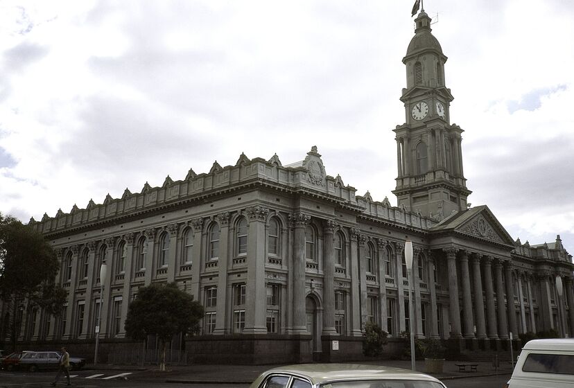 Large 19th century building with clock tower and columned entrance way