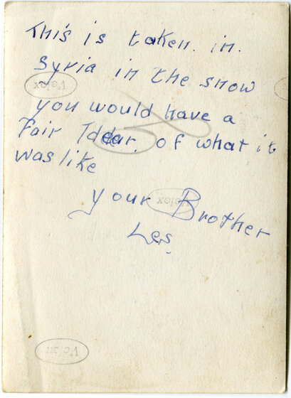 Reverse side of a photograph with handwritten text, 'This is taken in Syria in the snow. You would have a fair idea of what it was like. Your Brother, Les.'