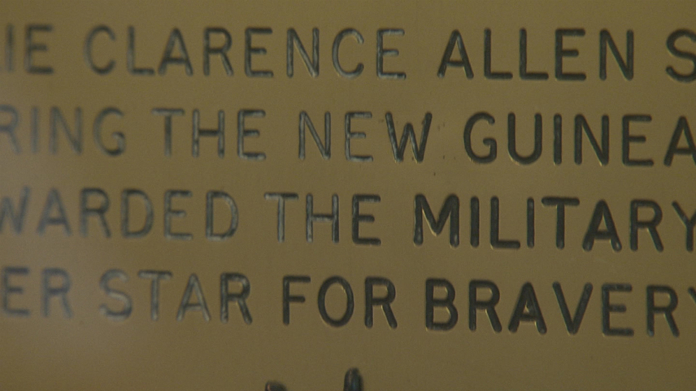 Detail of a brass plaque with black lettering.