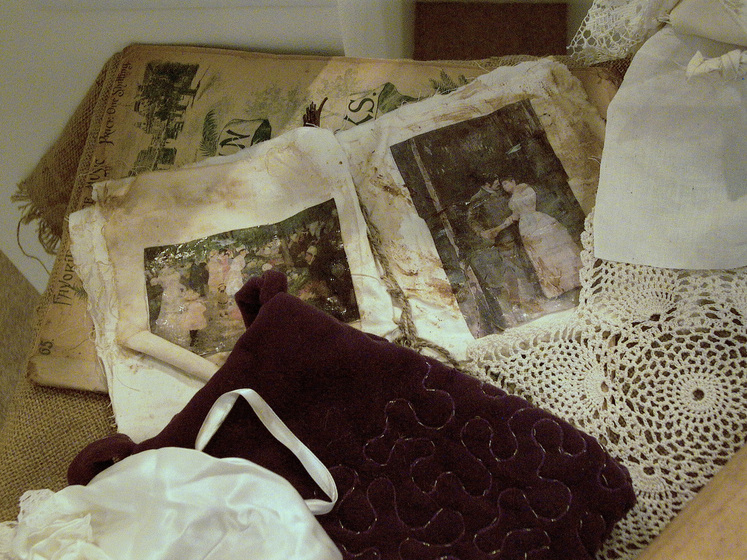 Selection of doyleys, garments and old black an white photographs.