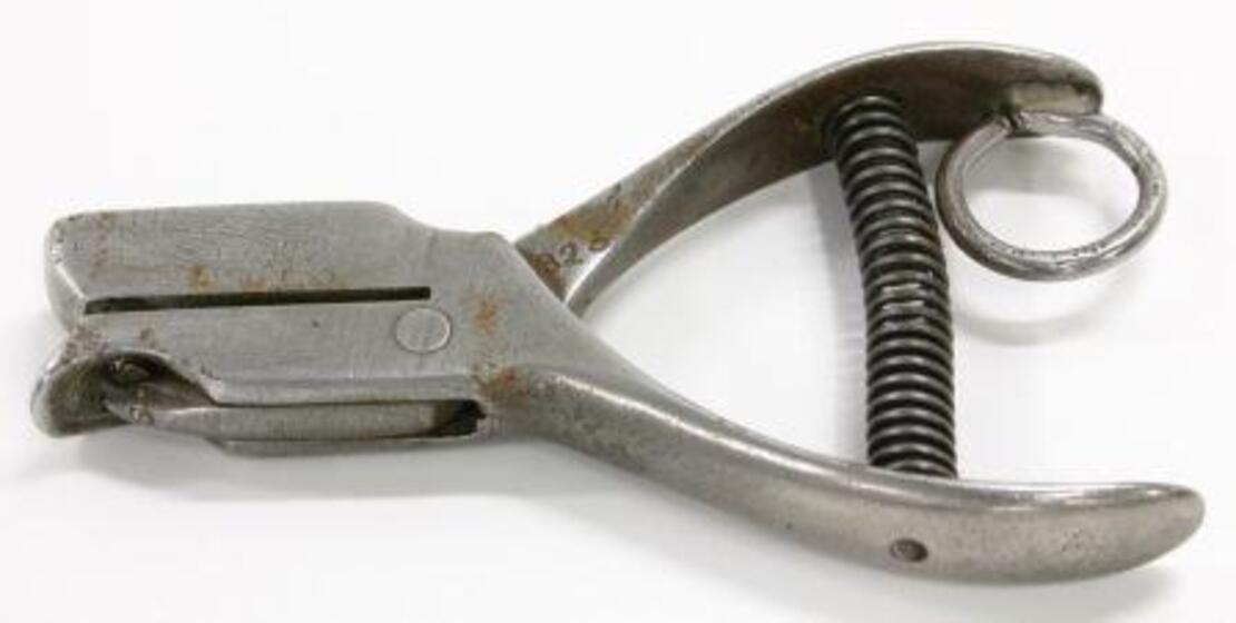 Colour photograph of a metal ticket puncher.