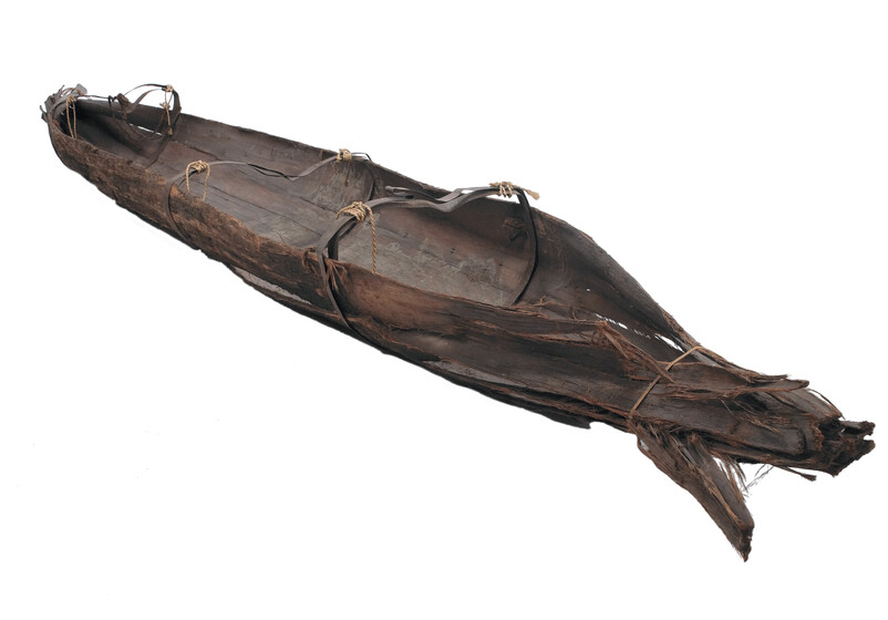 Colour photograph of an inverted bark canoe.