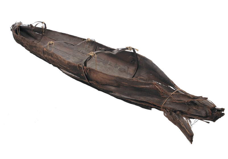 Colour photograph of an inverted bark canoe.