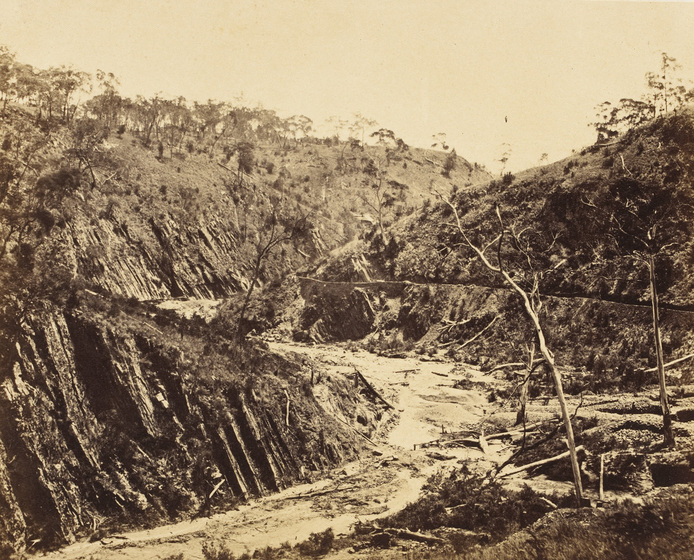 Sepia photograph of a denuded and eroded ravine.