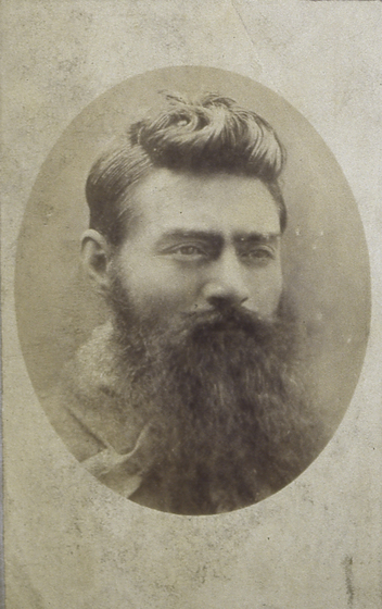 Oval sepia photo portrait of a young man with a long beard.