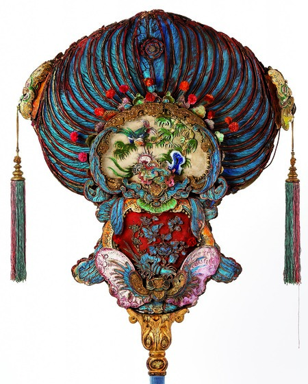 Colourful processional fan made of feathers and with tassels.