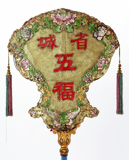 Detail of a colourful processional fan with tassels.