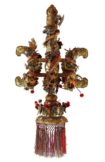 Elaborate gilt and polychrome fleur-de-lis-shaped finial with dragons, butterflies and a fringe.