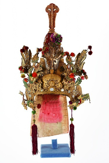 Ornate gilt headdress with mirrors and feathers.