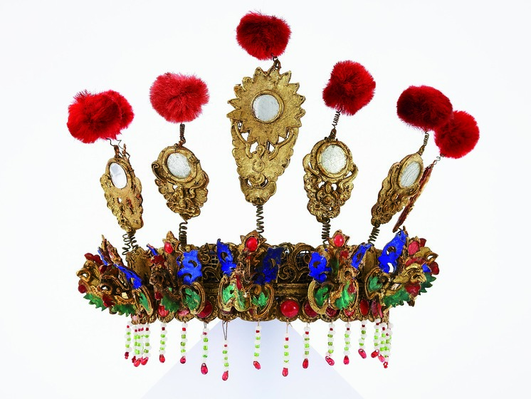 Decorative gilt and polychrome headdress with mirrors, pom-poms and beaded fringe.