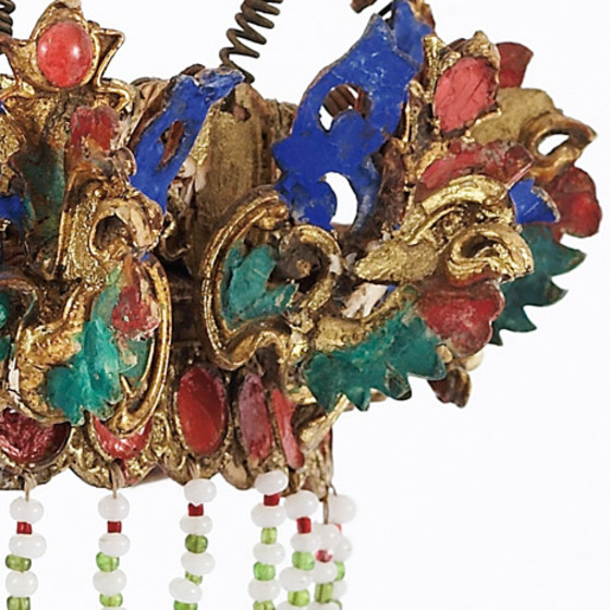 Decorative gilt and polychrome headdress with mirrors, pom-poms and beaded fringe.