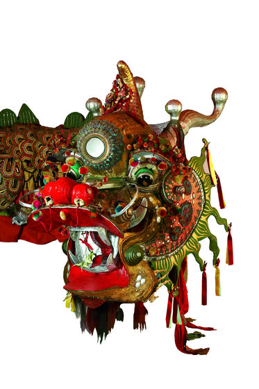 Elaborate head of a polychrome and gilt dragon costume with mirrors and ribbons.