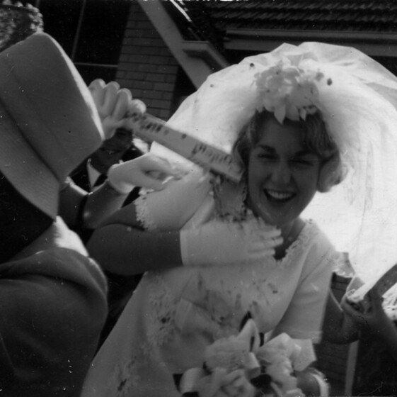 Black and white photograph of confetti being sprinkled over a bride.