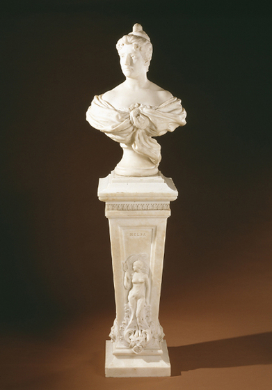 White marble bust of a woman in a décolleté neckline and her hair up, on a white marble pedestal. 