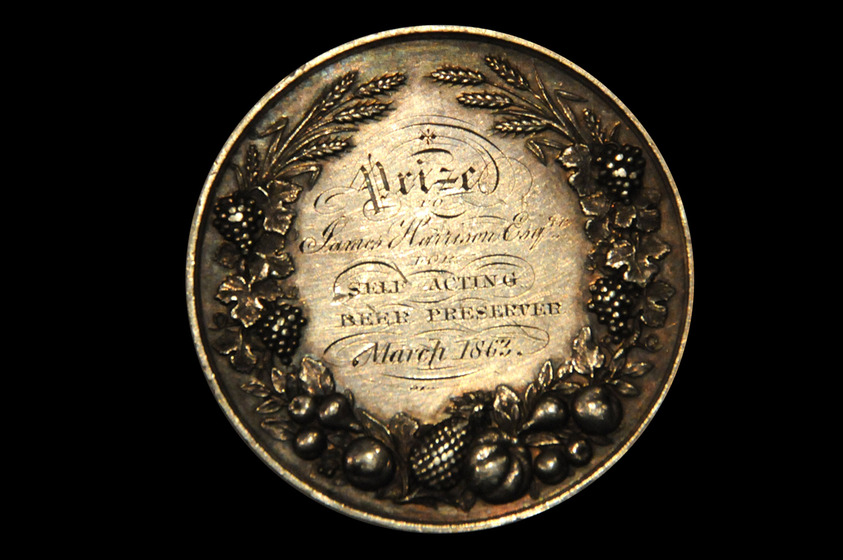 Round medal with the inscription 'Prize to James Harrison Esq. for Self Acting Beer Preserver March 1863' surrounded by a moulded swag of fruit and grain.
