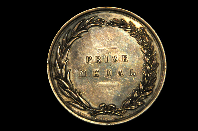 Round medal with the inscription 'Prize Medal' surrounded by a moulded wreath.