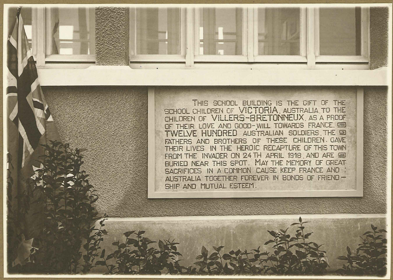 Black and white photograph of a plaque on a building.