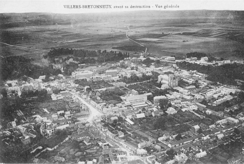 Black and white photo postcard of the aerial view of a rural European village.'