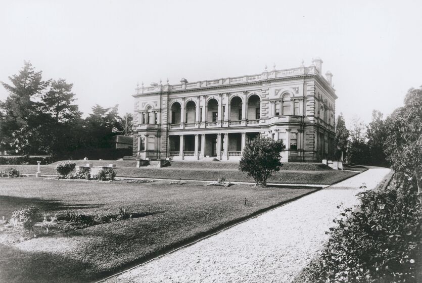 Black and white photograph of a large two-storey Victorian mansion with bay windows surrounded by sloping lawns.