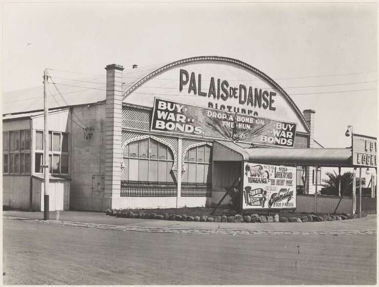 Black and white photograph of the facade of a one storey building with an arched gable and the sign, 'Palais de Danse'.