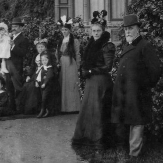 Black and white photograph of men, women and children standing in Victorian clothes.