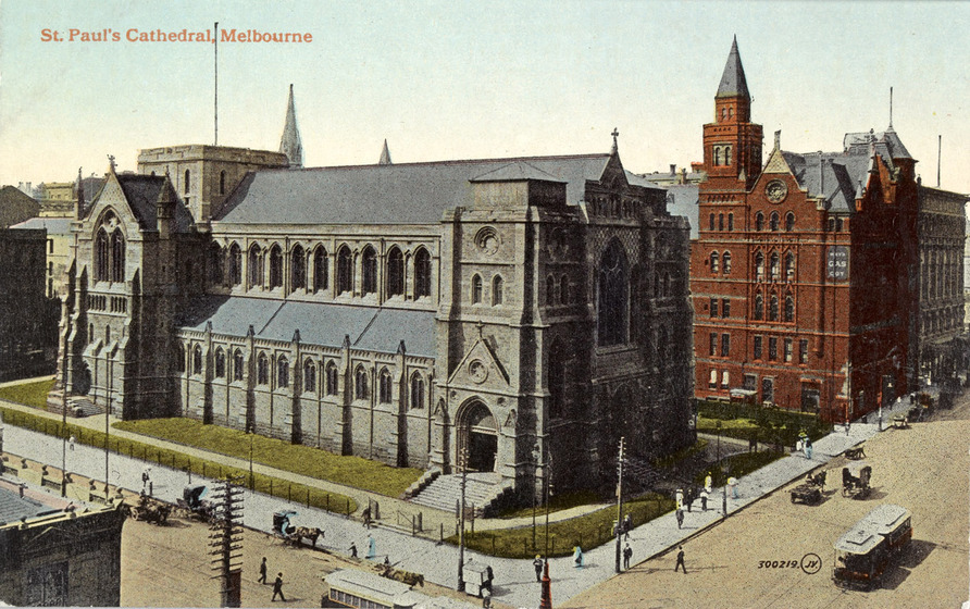 Tinted black and white photographic postcard of a cathedral without spires on a street corner. Tramcars on street. Labelled, 'St Paul's Cathedral, Melbourne'.