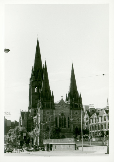 Black and white photograph of a Gothic Revival cathedral in a cityscape.